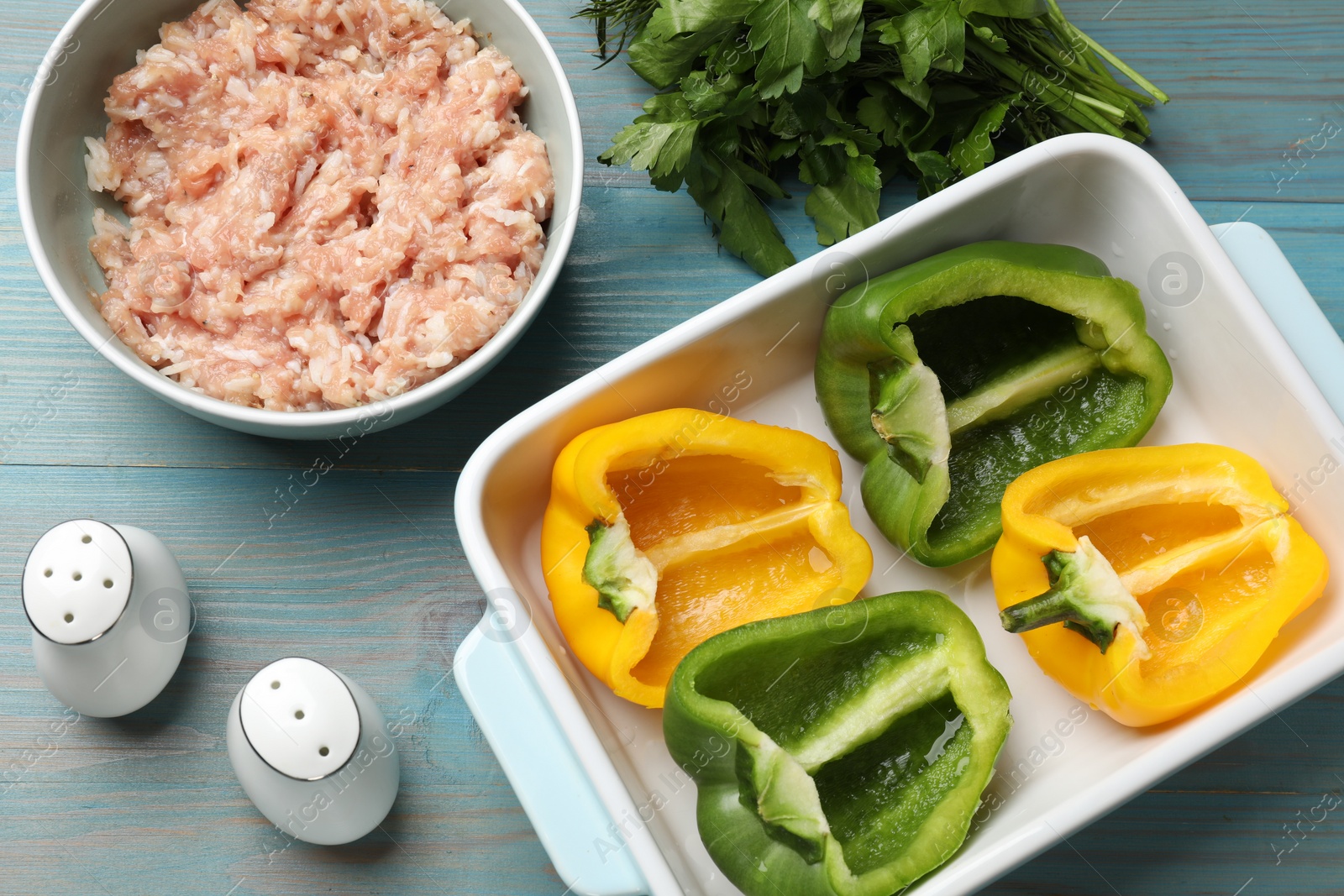 Photo of Making stuffed peppers. Vegetables, spices and ground meat on light blue wooden table, flat lay