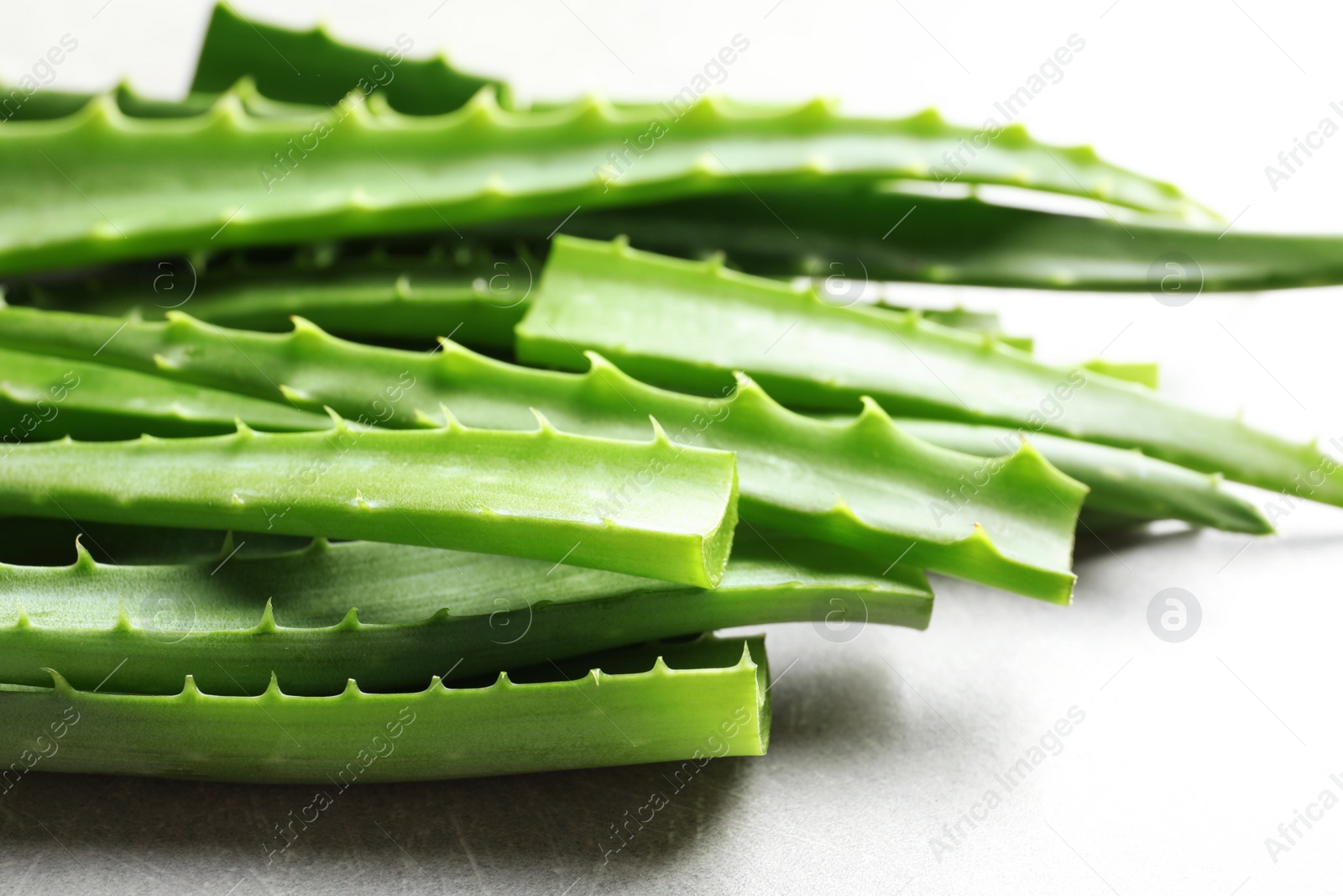 Photo of Fresh aloe vera leaves on gray table