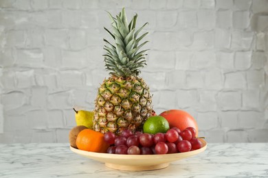 Photo of Fresh ripe fruits on white marble table