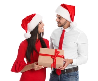 Lovely young couple in Santa hats with gift box on white background. Christmas celebration