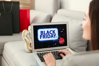 Photo of Woman using laptop with Black Friday announcement on screen, closeup