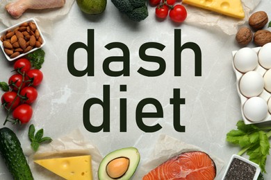 Dietary approaches to stop hypertension. Many different healthy food around words Dash diet on white marble table, flat lay