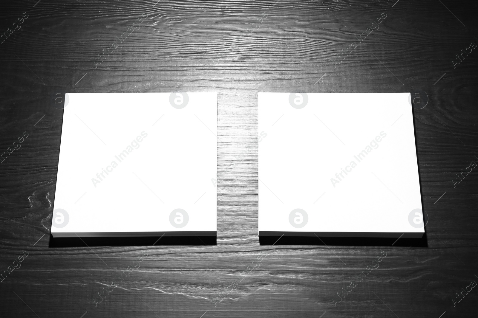 Photo of Blank paper sheets for brochure on black wooden background. Mock up