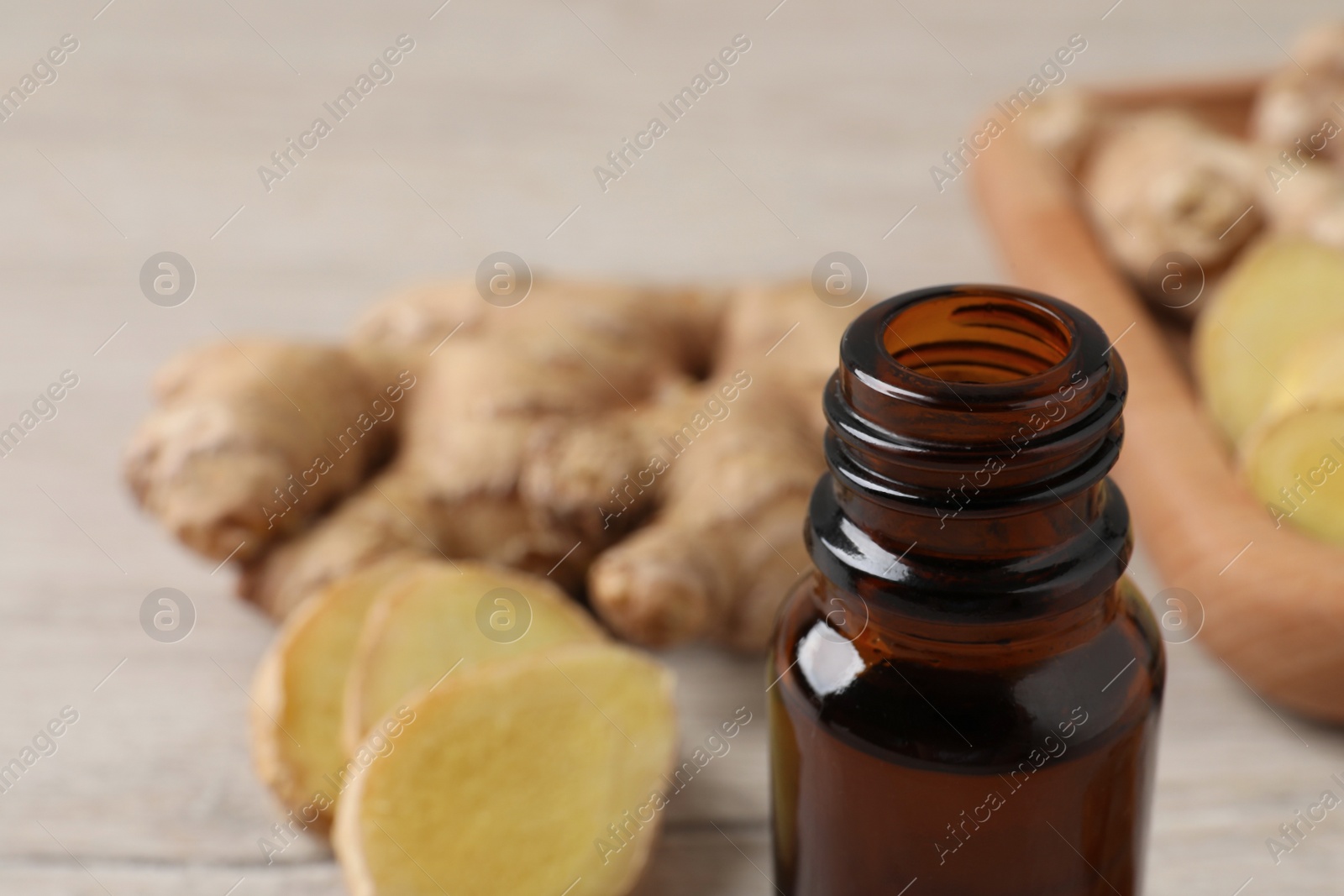 Photo of Glass bottle of ginger essential oil on table, closeup. Space for text