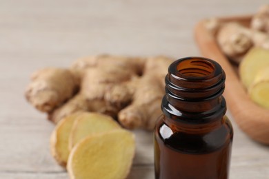 Photo of Glass bottle of ginger essential oil on table, closeup. Space for text