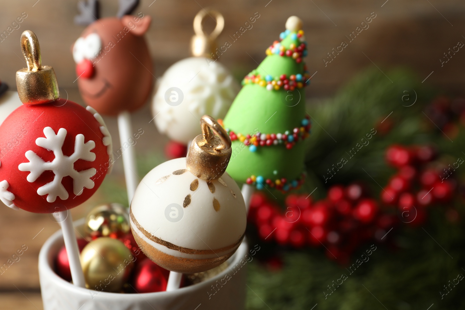 Photo of Delicious Christmas themed cake pops on blurred background, closeup