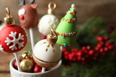Delicious Christmas themed cake pops on blurred background, closeup