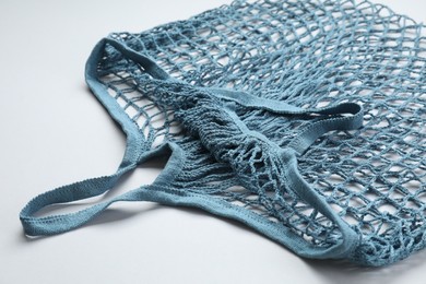 Photo of Blue string bag on light grey background, closeup