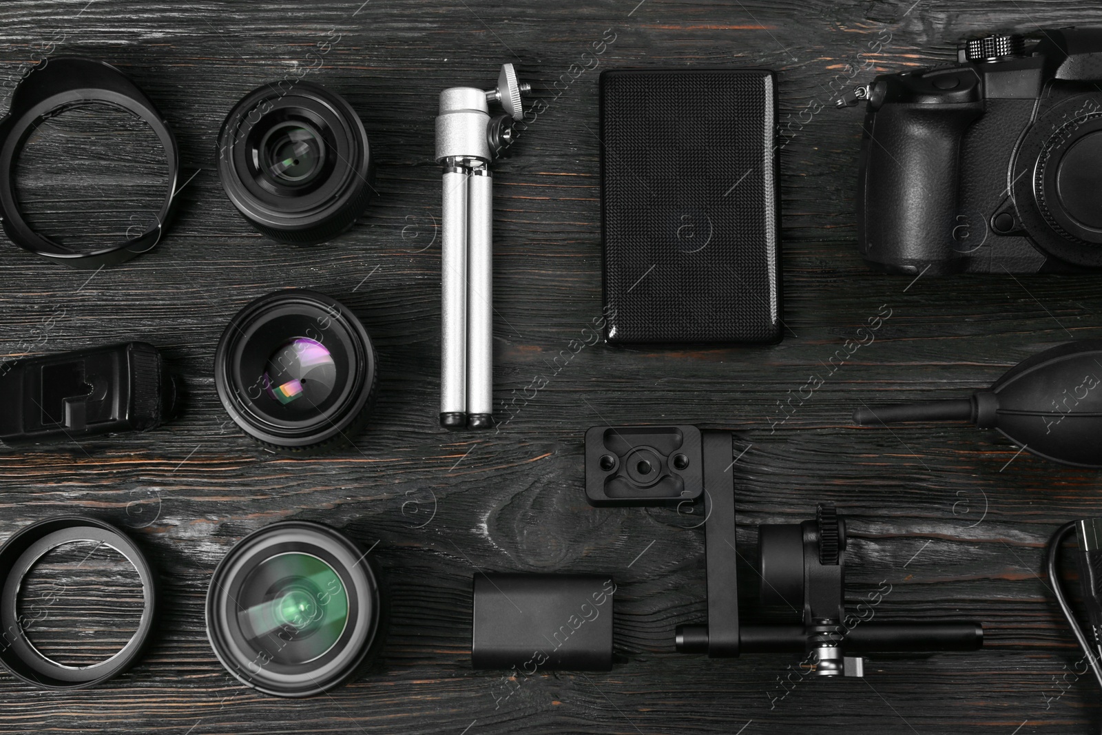 Photo of Flat lay composition with camera and video production equipment on black wooden table