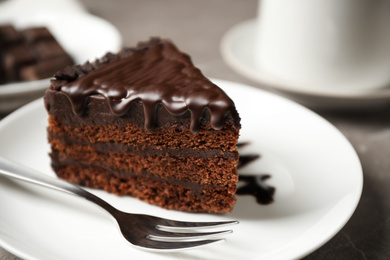 Photo of Tasty chocolate cake served on grey table, closeup