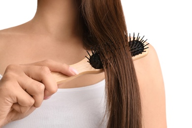 Woman with hair brush on white background, closeup