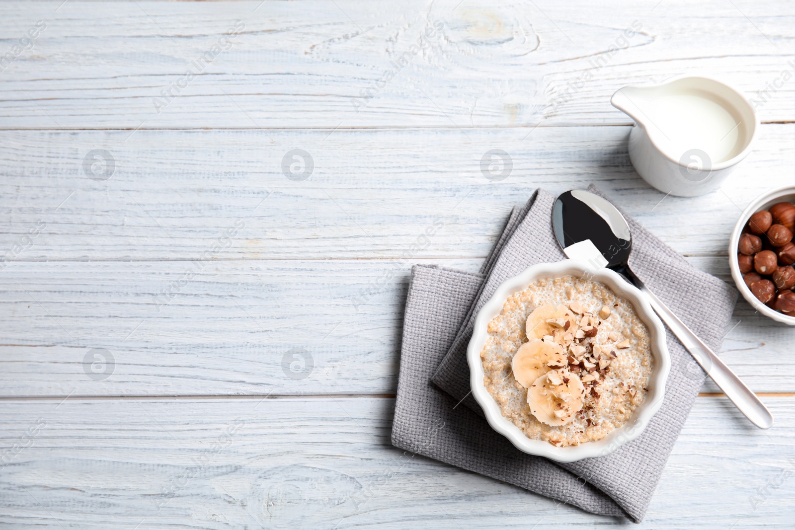 Photo of Flat lay composition with quinoa porridge, cream and space for text on wooden background