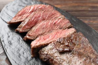 Photo of Pieces of delicious grilled beef meat on table, closeup