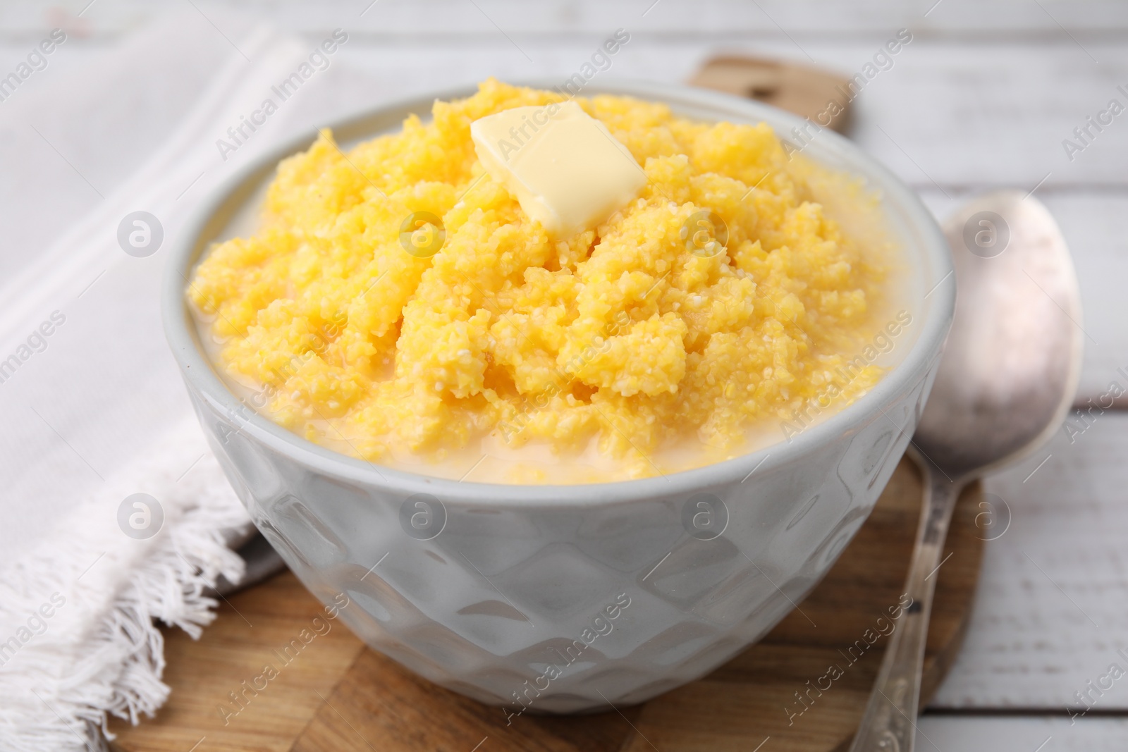 Photo of Tasty cornmeal with butter in bowl served on table, closeup