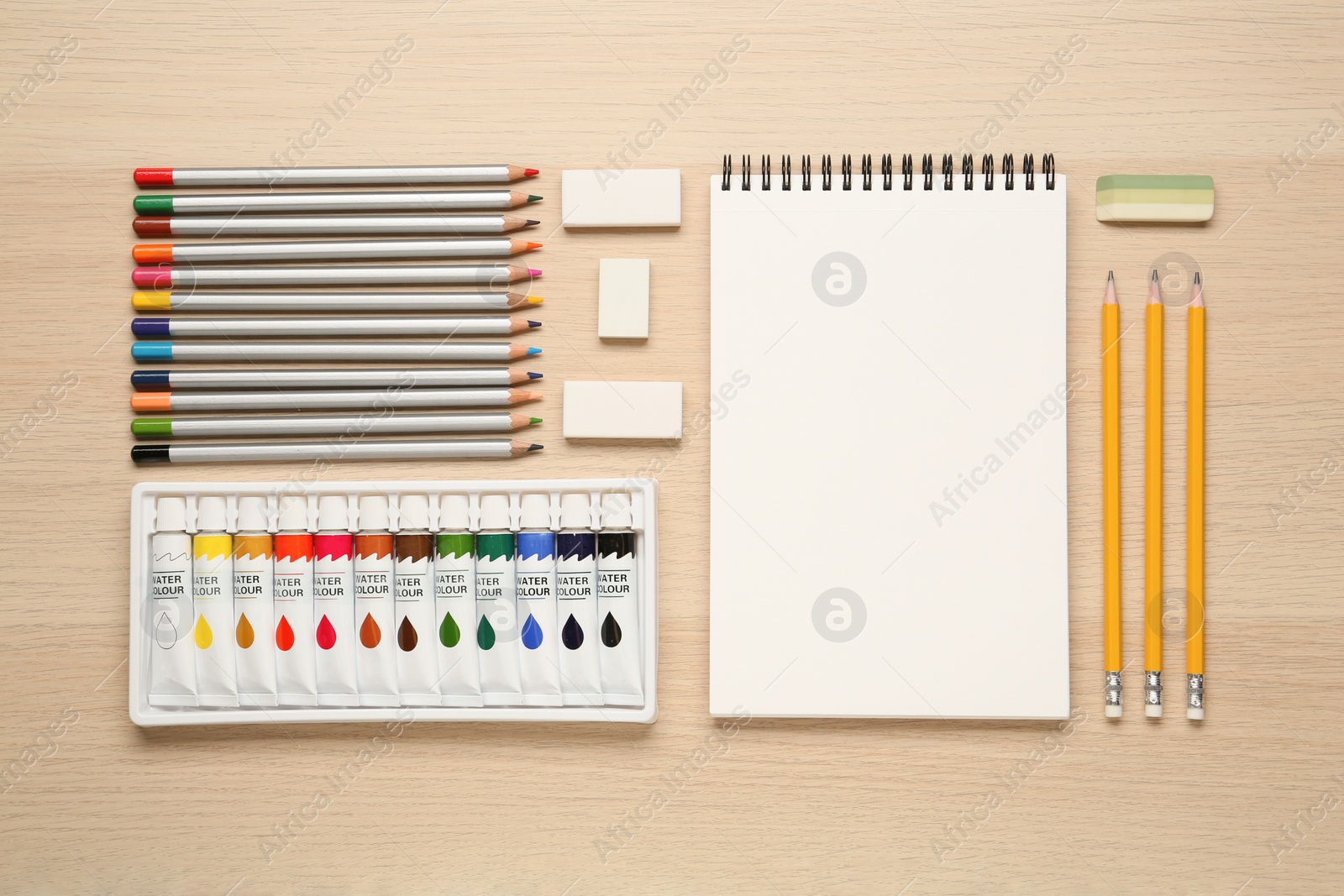 Photo of Flat lay composition with sketchbook and drawing tools on wooden table