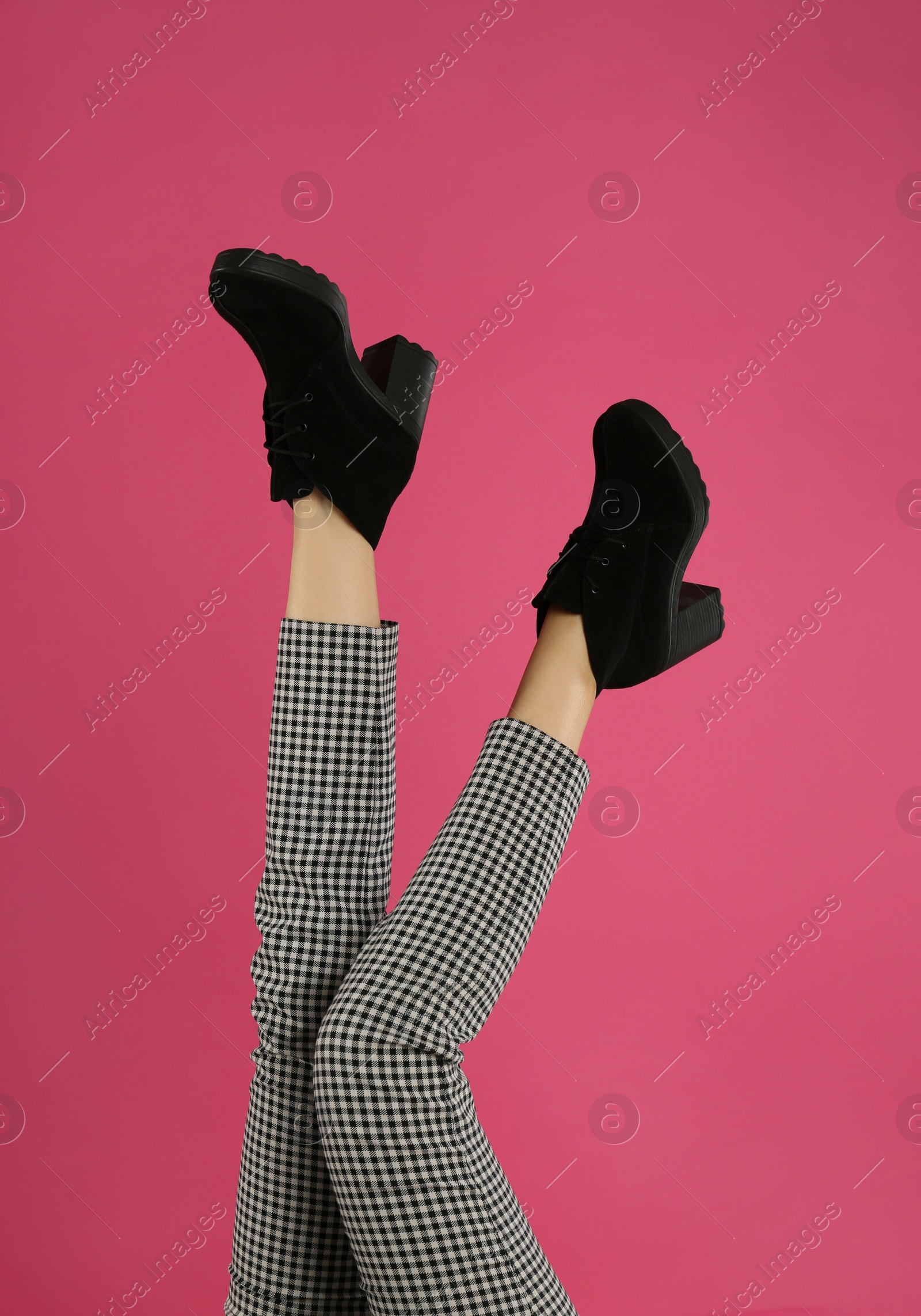 Photo of Woman wearing stylish boots on pink background, closeup