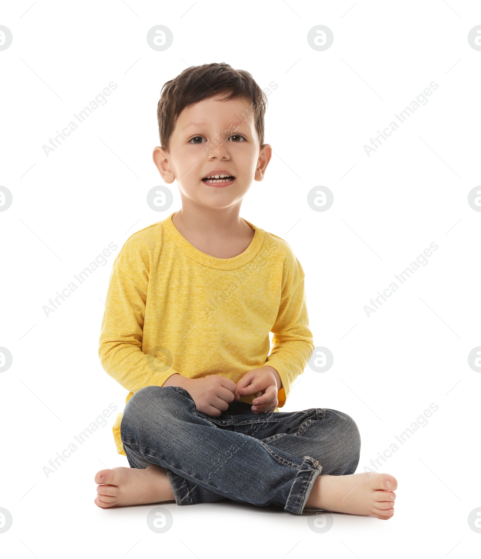 Photo of Portrait of cute little boy sitting on white background