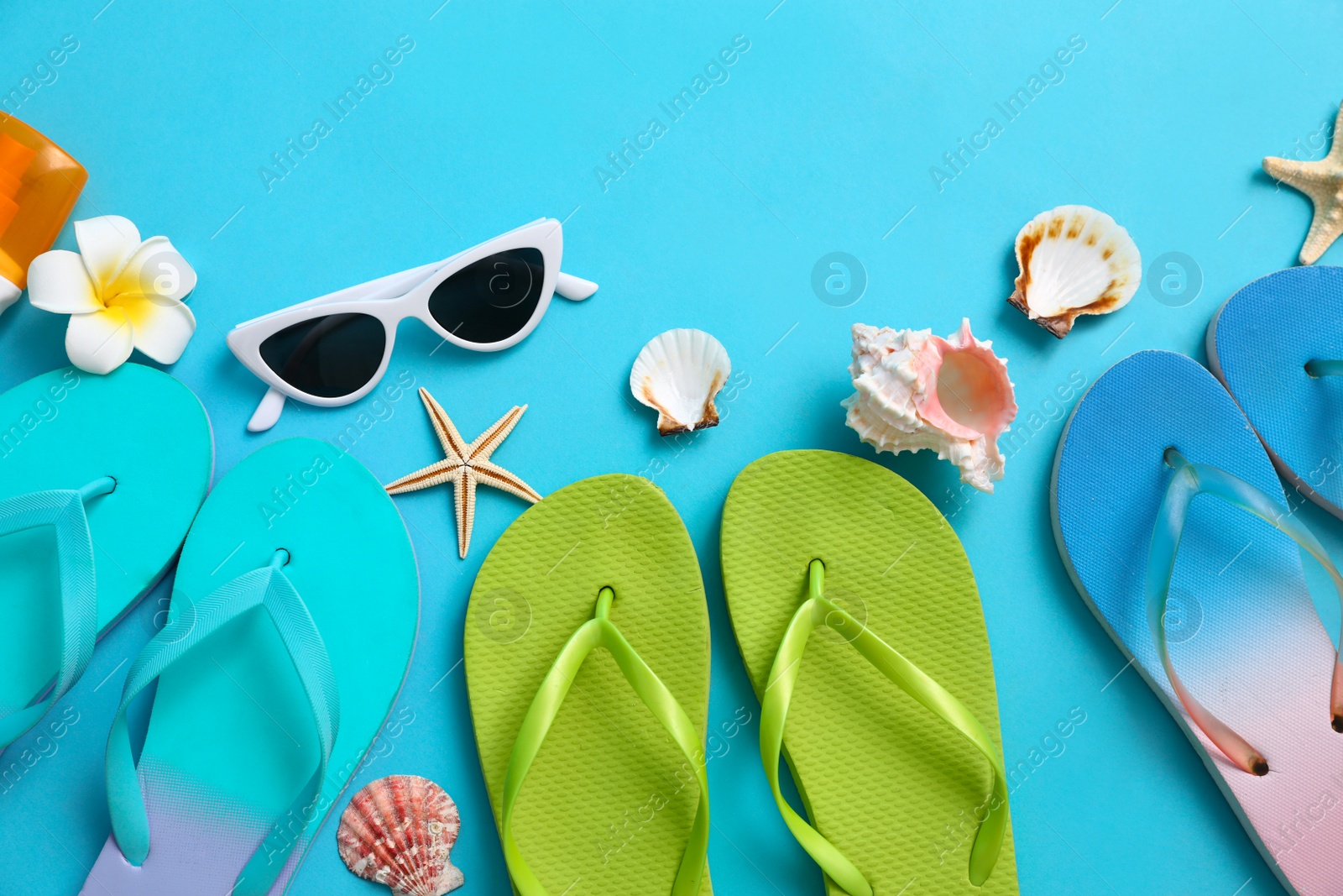 Photo of Flat lay composition with different flip flops on blue background, space for text. Summer beach accessories