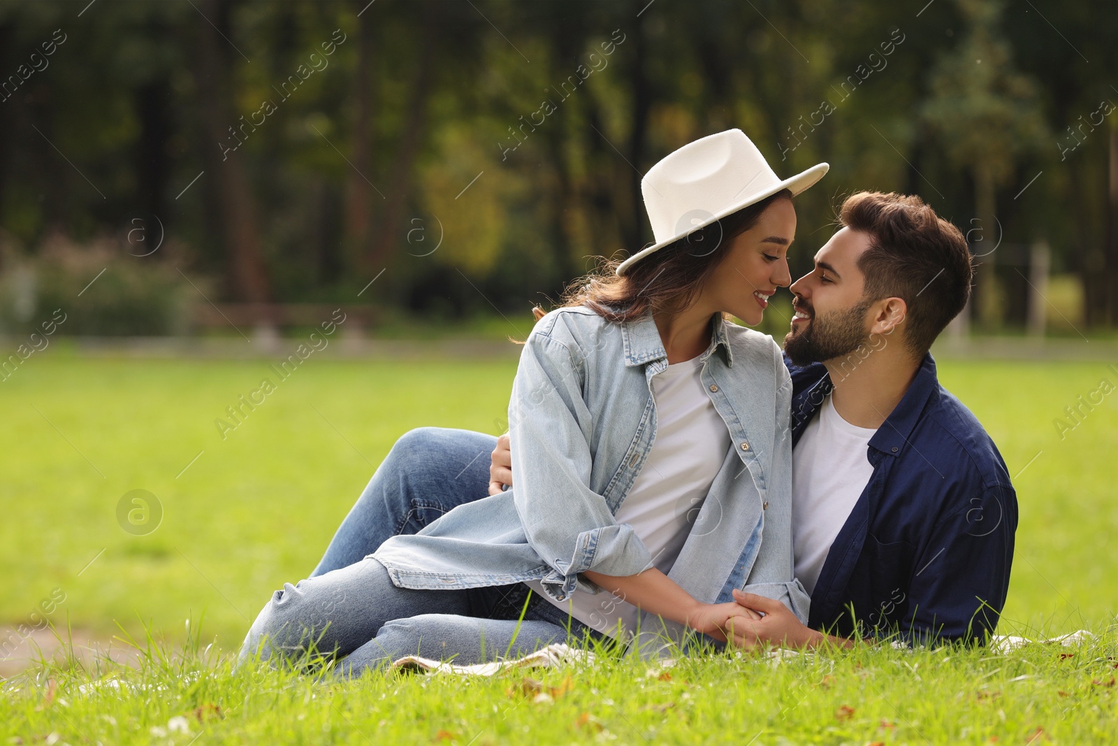 Photo of Beautiful couple spending time together in park, space for text