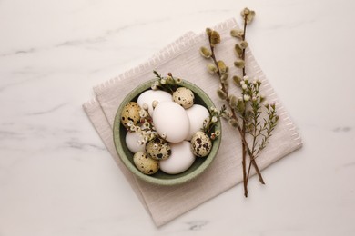 Photo of Easter eggs, flowers and pussy willow branches on white marble table, top view