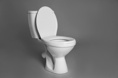 Photo of New ceramic toilet bowl on grey background