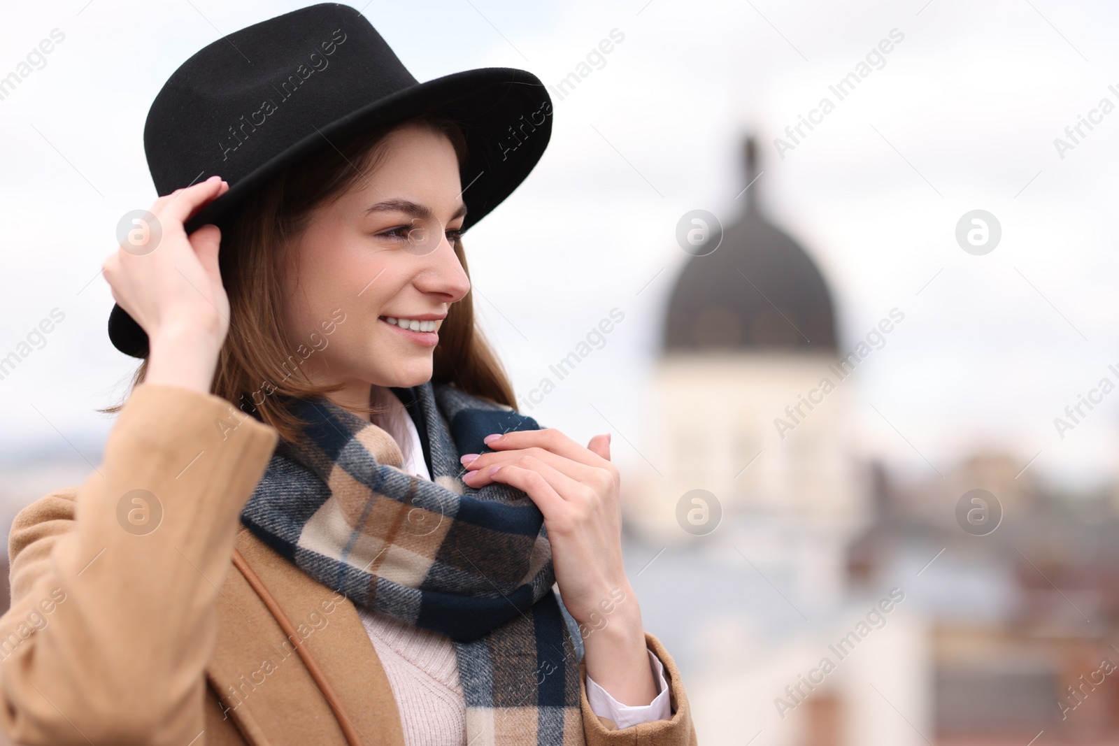 Photo of Beautiful woman in warm scarf and hat outdoors, space for text