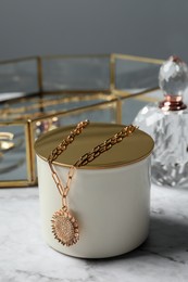 Photo of Stylish presentation of elegant necklace on white marble table