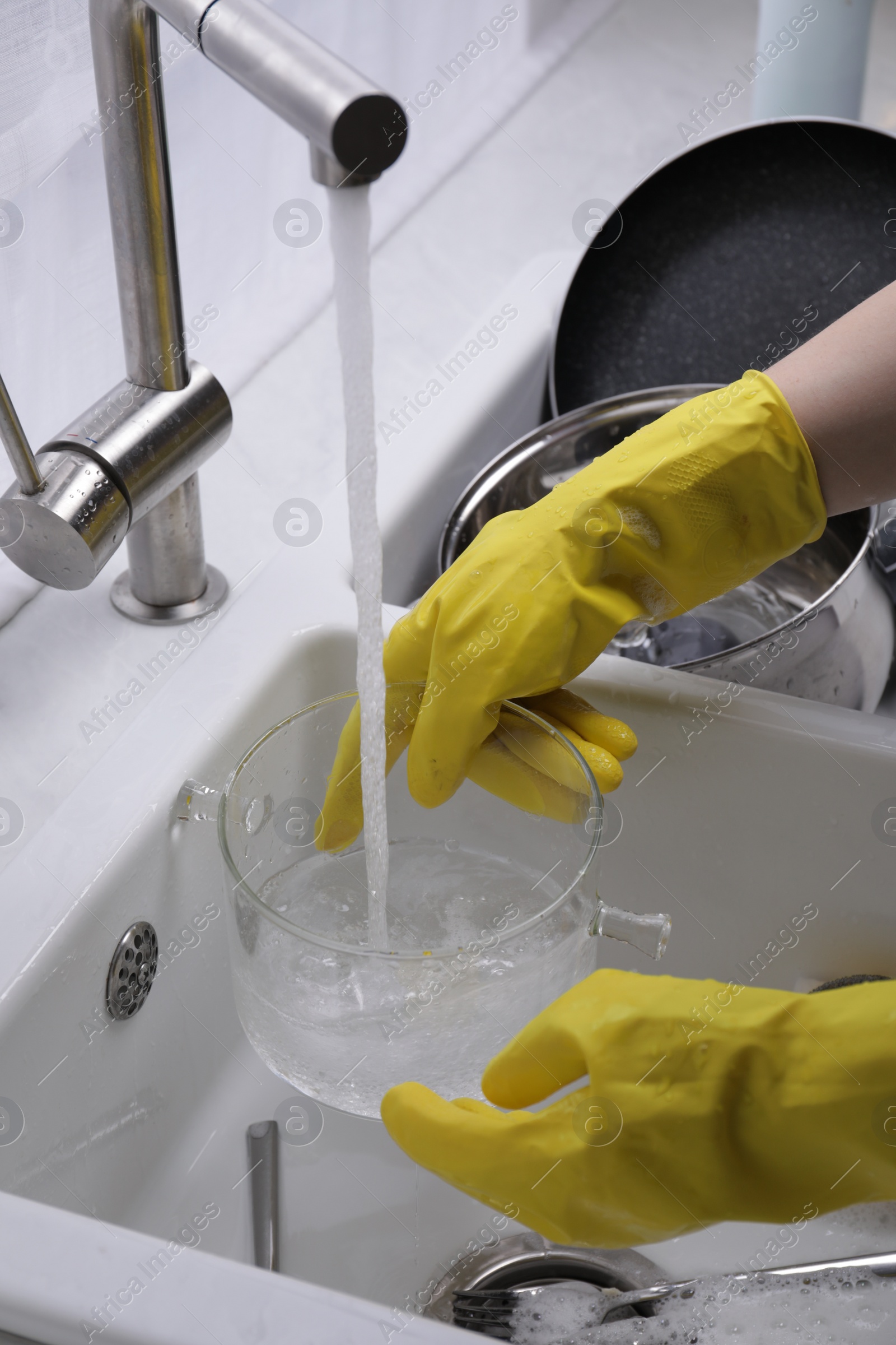 Photo of Woman washing dirty dishes in kitchen sink, closeup