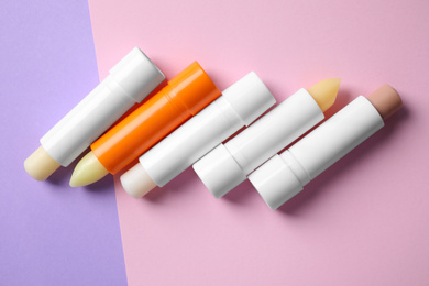 Hygienic lipsticks on color background, flat lay