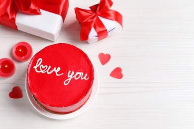 Photo of Bento cake with text Love You, gift boxes, candles and paper hearts on white wooden table, space for text. St. Valentine's day surprise