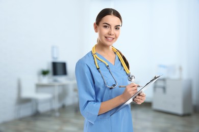 Nurse with stethoscope and clipboard in uniform at hospital