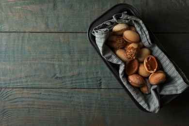 Photo of Freshly baked homemade walnut shaped cookies with condensed milk on wooden table, top view. Space for text