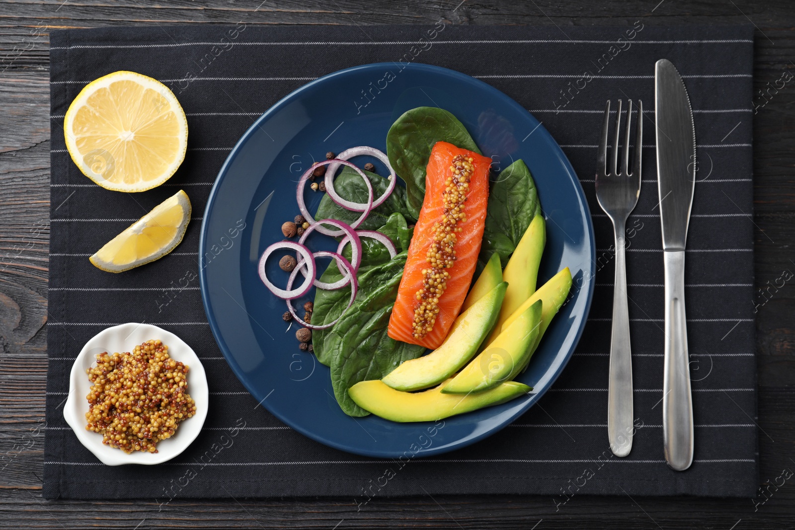 Photo of Delicious salmon with spinach and avocado served on black wooden table, flat lay