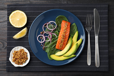 Photo of Delicious salmon with spinach and avocado served on black wooden table, flat lay