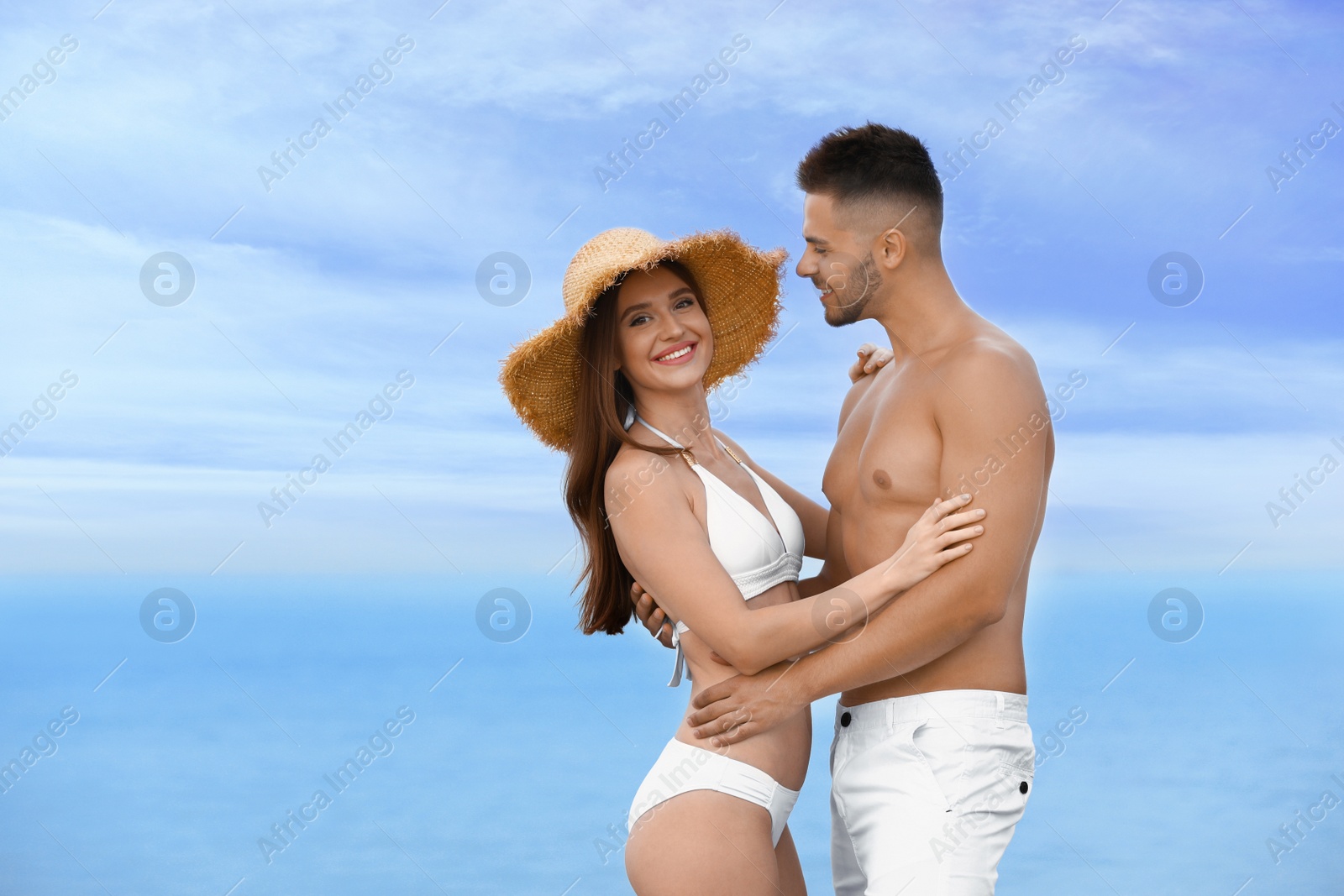 Photo of Young woman in bikini with her boyfriend on beach, space for text. Lovely couple