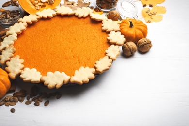 Photo of Delicious homemade pumpkin pie on white wooden table. Space for text