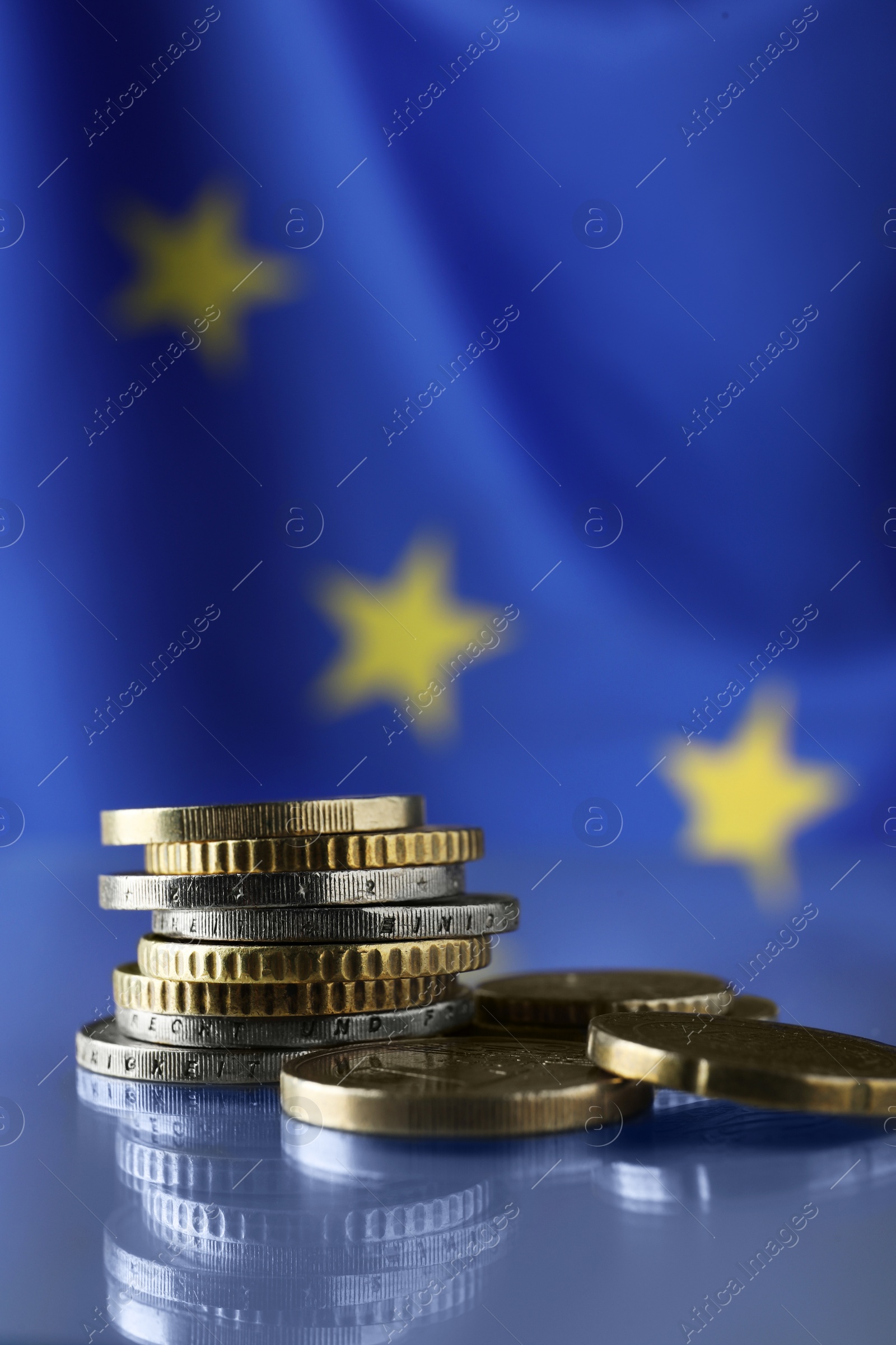 Photo of Coins on table against European Union flag, closeup. Space for text