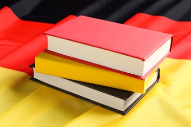 Photo of Learning foreign language. Different books on flag of Germany