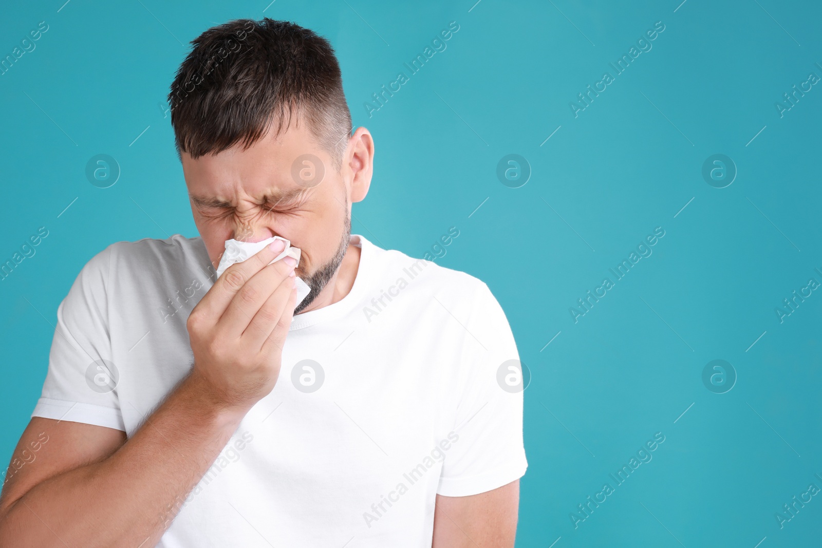 Photo of Man suffering from allergy on blue background. Space for text