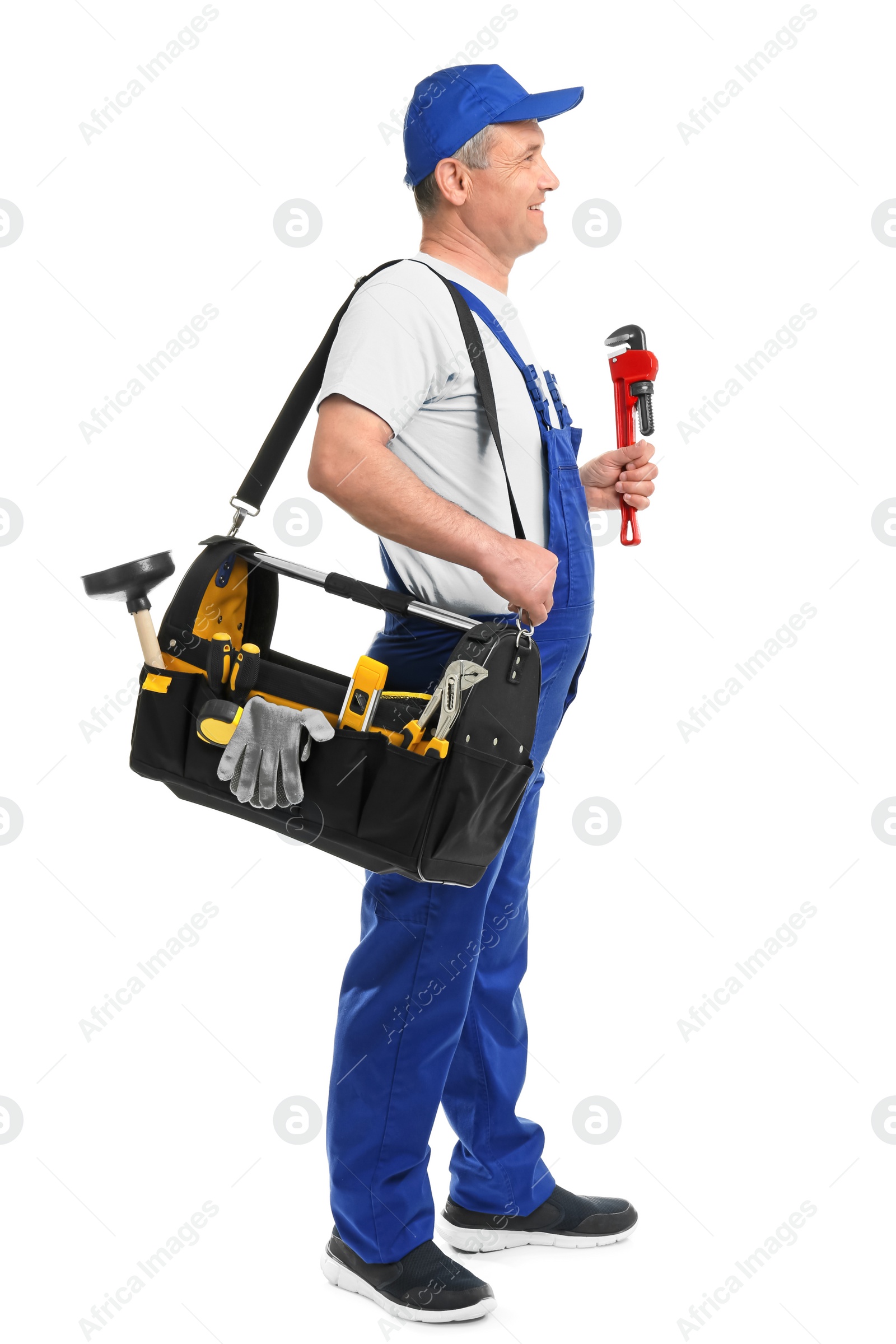 Photo of Mature plumber with pipe wrench and tool bag on white background