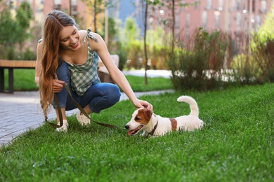 Photo of Young woman with adorable Jack Russell Terrier dog outdoors