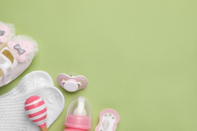 Photo of Flat lay composition with pacifier and other baby stuff on pale green background. Space for text