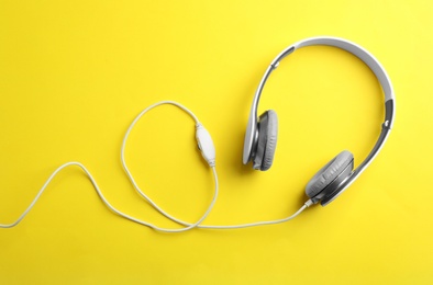 Stylish headphones on color background, top view