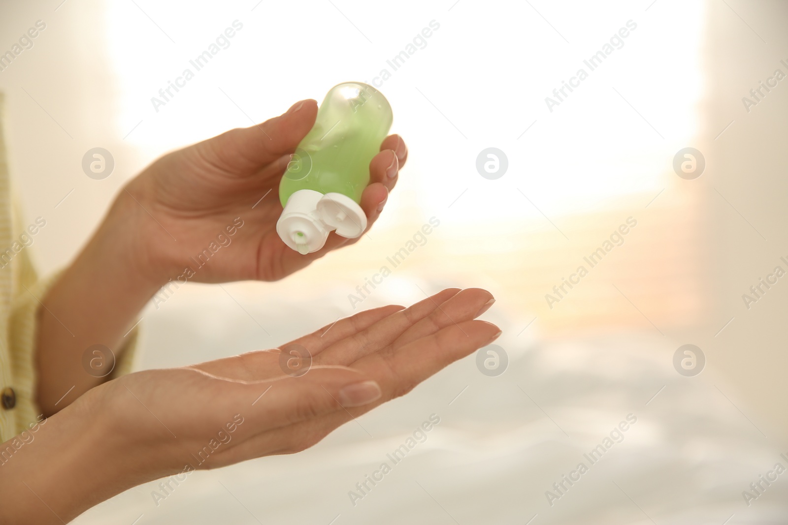 Photo of Woman applying antiseptic gel on blurred background, closeup