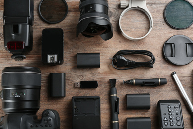 Photo of Flat lay composition with equipment for professional photographer on wooden table