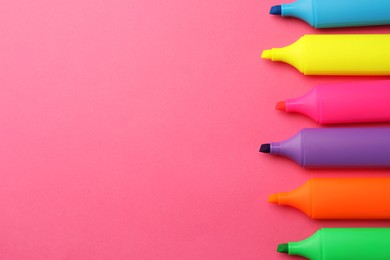 Photo of Bright color markers on pink background, flat lay. Space for text