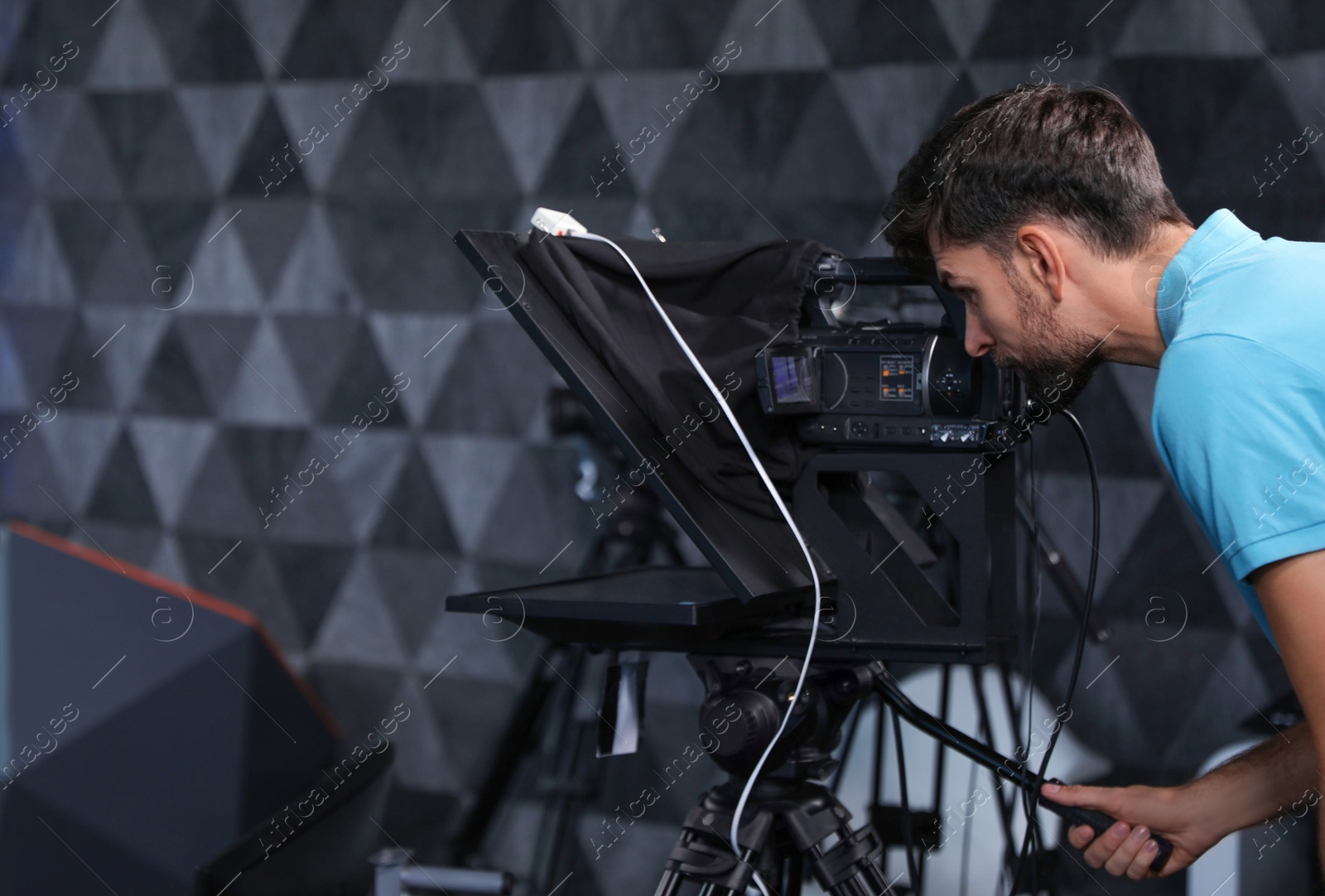 Photo of Professional video camera operator working in studio