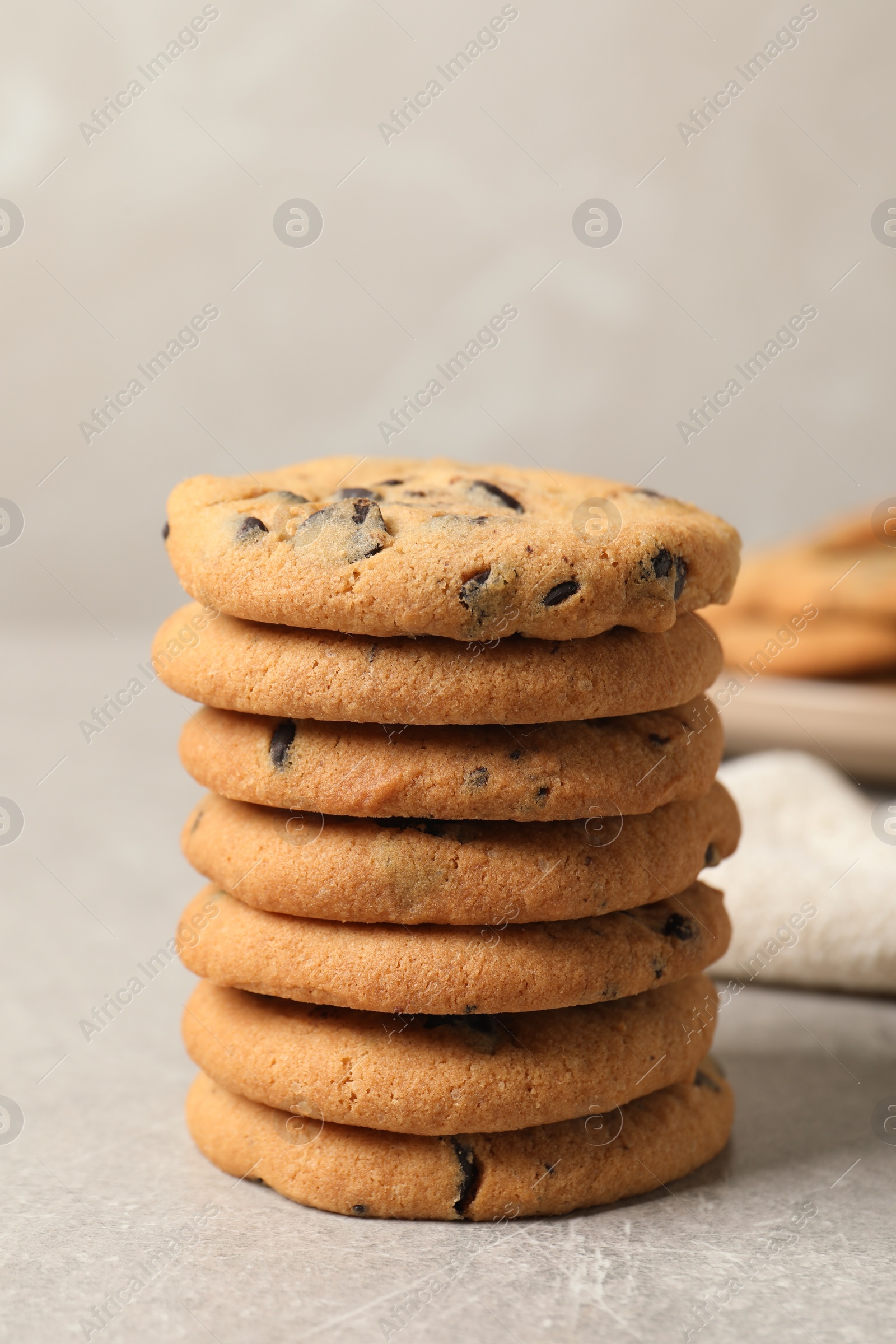 Photo of Stack of tasty chocolate chip cookies on grey table