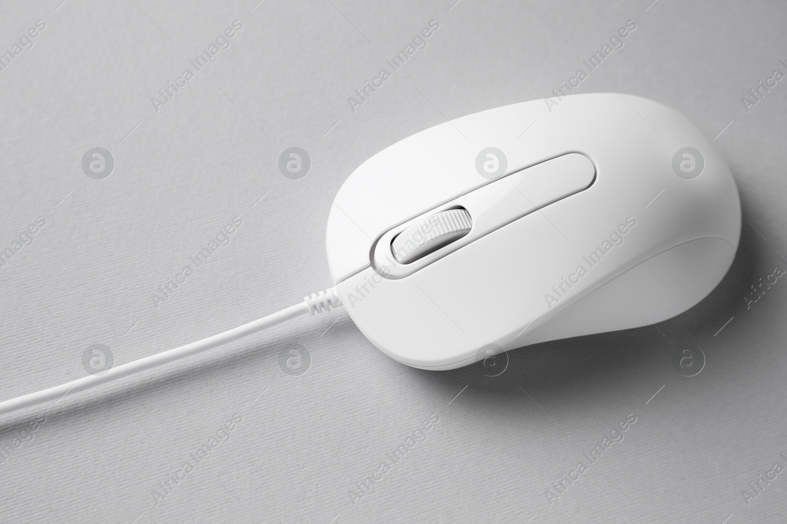 Photo of One wired mouse on grey background, closeup