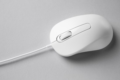 Photo of One wired mouse on grey background, closeup